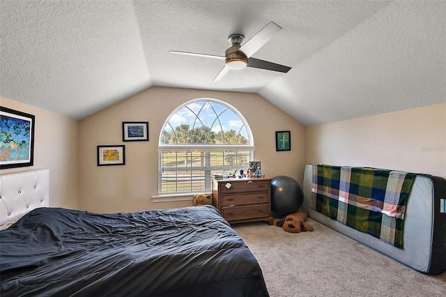 bedroom featuring ceiling fan, vaulted ceiling, light carpet, and a textured ceiling