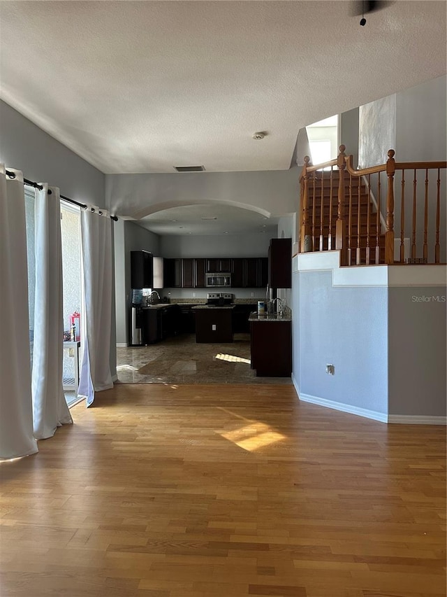 unfurnished living room featuring a textured ceiling and hardwood / wood-style floors