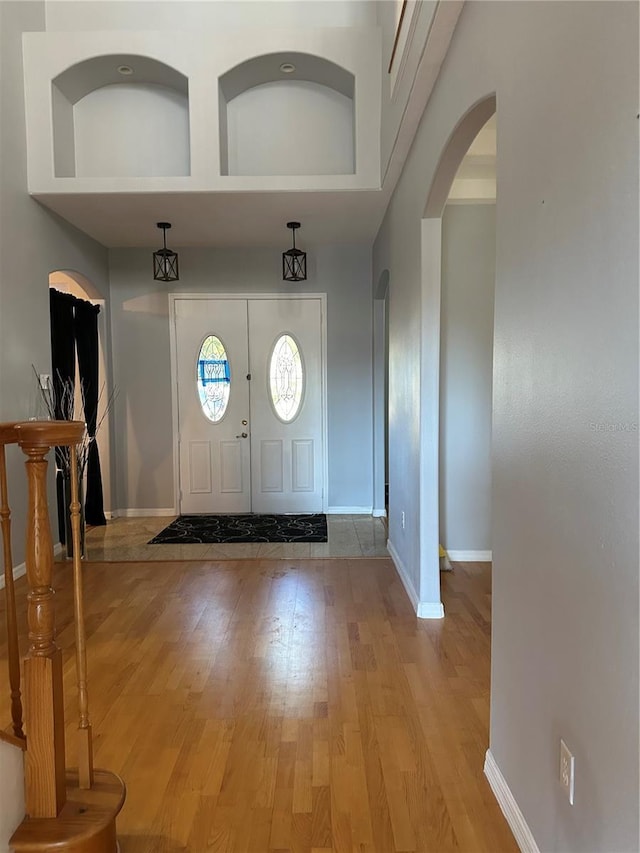 foyer entrance with a high ceiling and light wood-type flooring