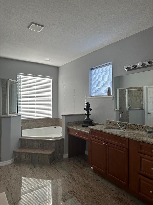 bathroom featuring a textured ceiling, shower with separate bathtub, and vanity