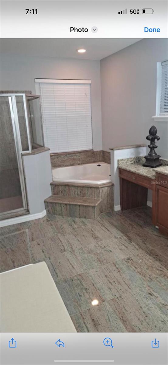 bathroom featuring plus walk in shower and vanity