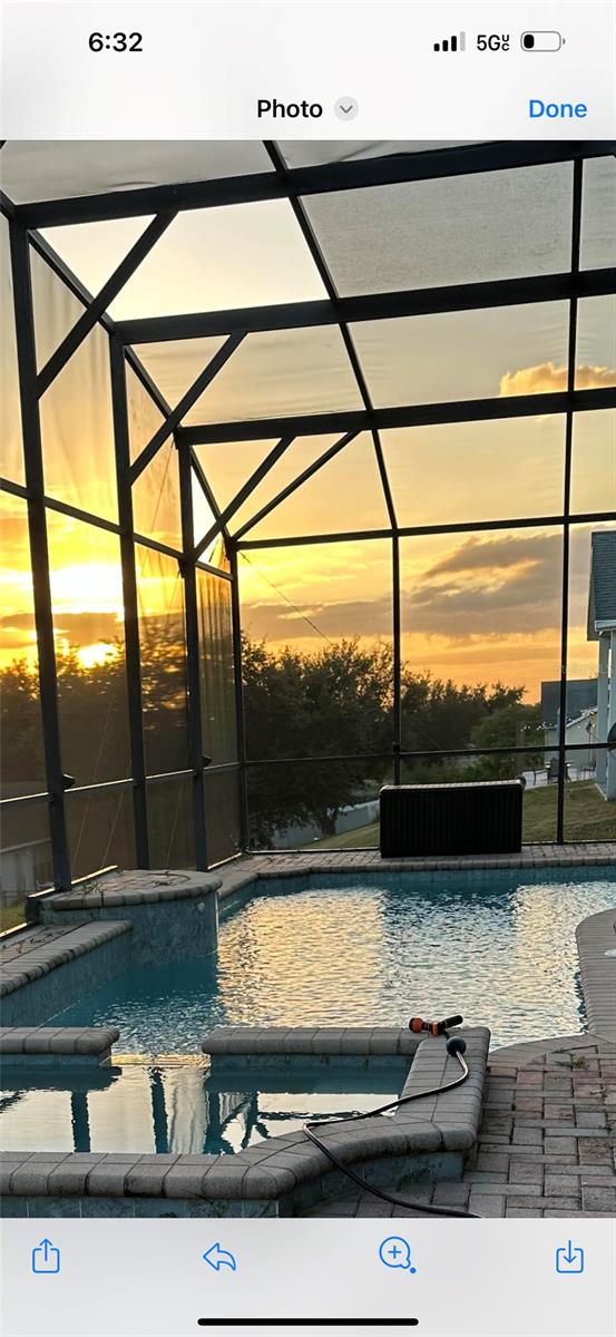 pool at dusk featuring a lanai