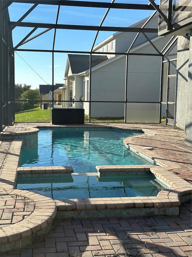 view of pool featuring a patio area, an in ground hot tub, and glass enclosure