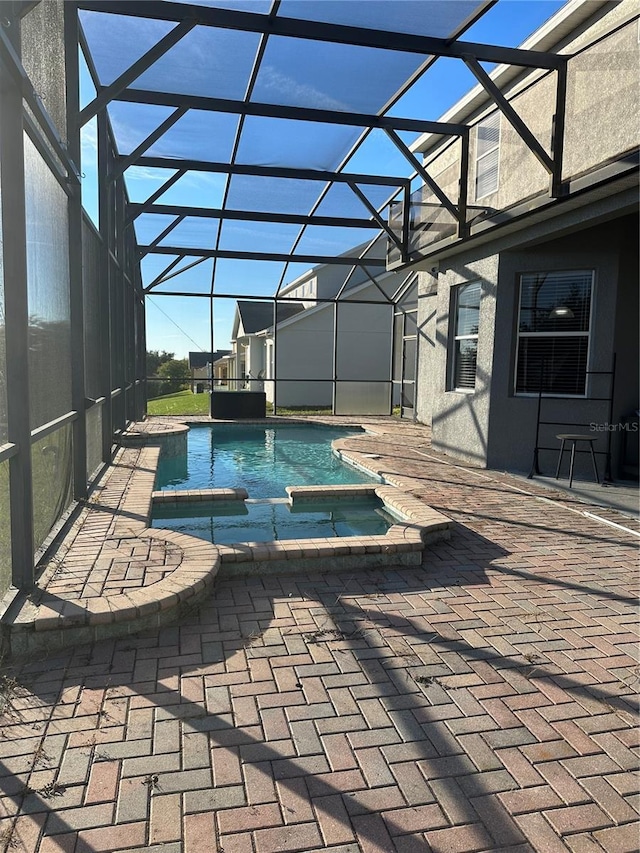 view of swimming pool featuring a lanai, a patio, and an in ground hot tub