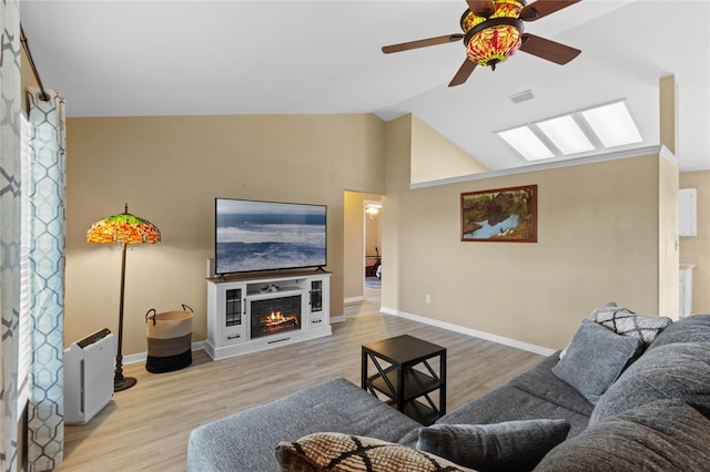 living room with lofted ceiling, ceiling fan, and light hardwood / wood-style flooring