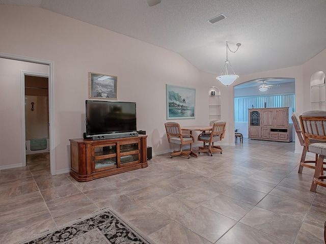 living room featuring a textured ceiling, ceiling fan, lofted ceiling, and built in shelves