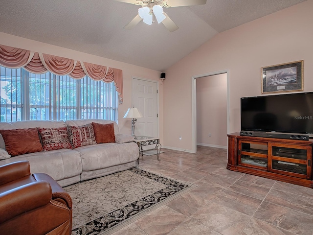 living room featuring vaulted ceiling, ceiling fan, and a textured ceiling