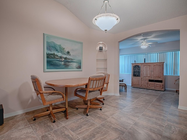 dining area featuring ceiling fan, a textured ceiling, and vaulted ceiling