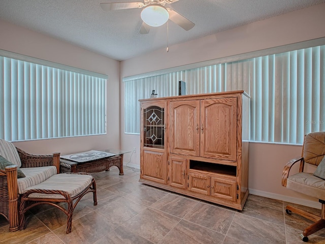 sitting room featuring ceiling fan and a textured ceiling