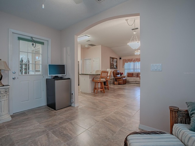 interior space with vaulted ceiling and a textured ceiling