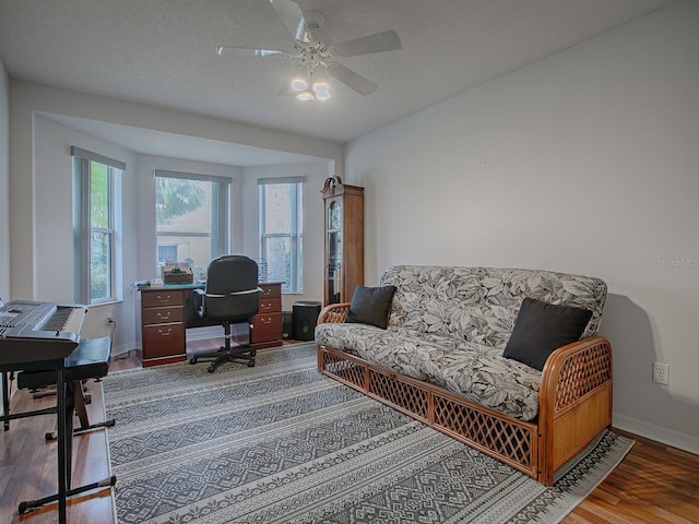 home office with ceiling fan, a textured ceiling, and hardwood / wood-style floors