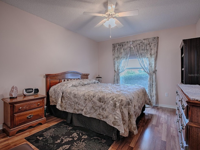 bedroom with ceiling fan, dark hardwood / wood-style floors, and a textured ceiling