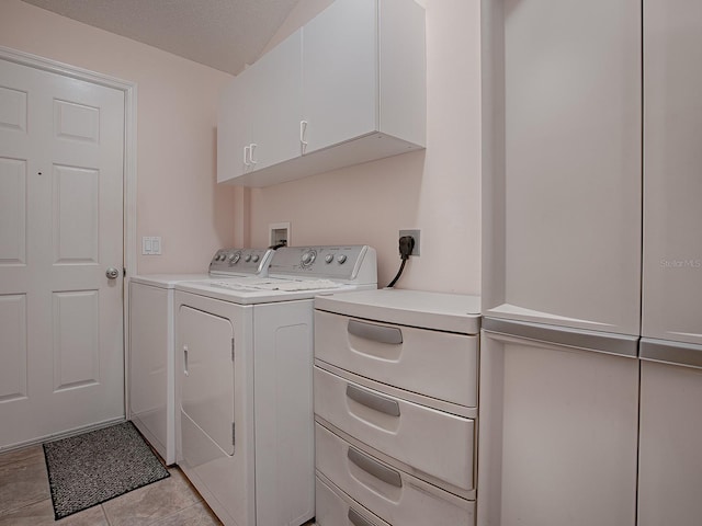 laundry room with cabinets, a textured ceiling, and washer and clothes dryer