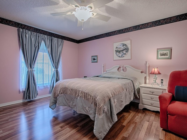 bedroom with ceiling fan, wood-type flooring, and a textured ceiling