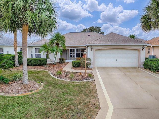 ranch-style home featuring a front yard, cooling unit, and a garage