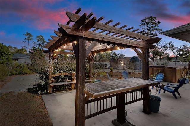 patio terrace at dusk with a pergola and a hot tub