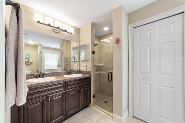 bathroom with vanity, tile patterned floors, a textured ceiling, and walk in shower