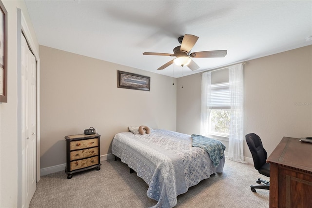 bedroom featuring light carpet, ceiling fan, and a closet