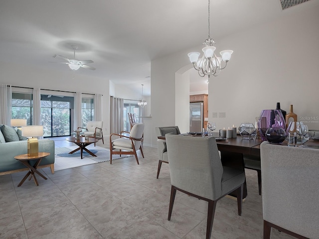 dining area with ceiling fan with notable chandelier and lofted ceiling