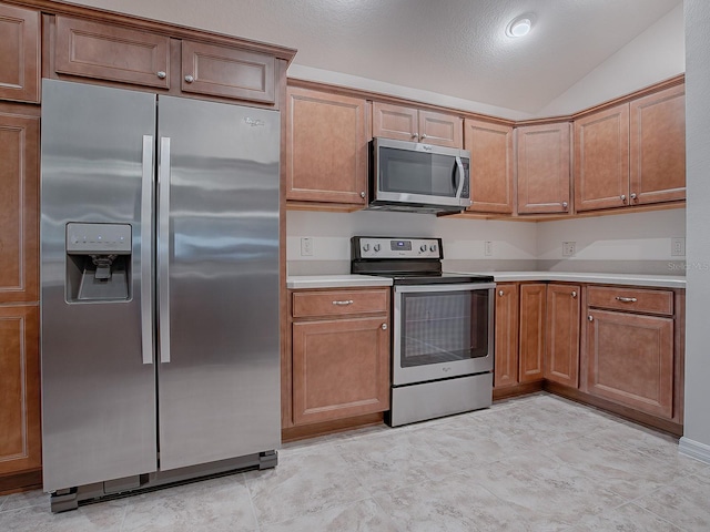 kitchen with vaulted ceiling and appliances with stainless steel finishes