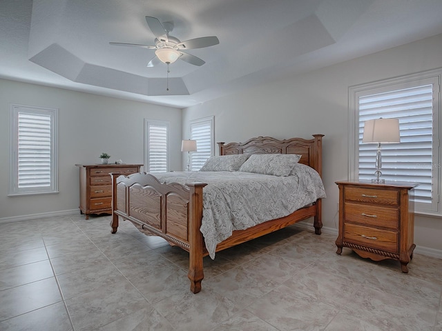 bedroom with ceiling fan and a tray ceiling