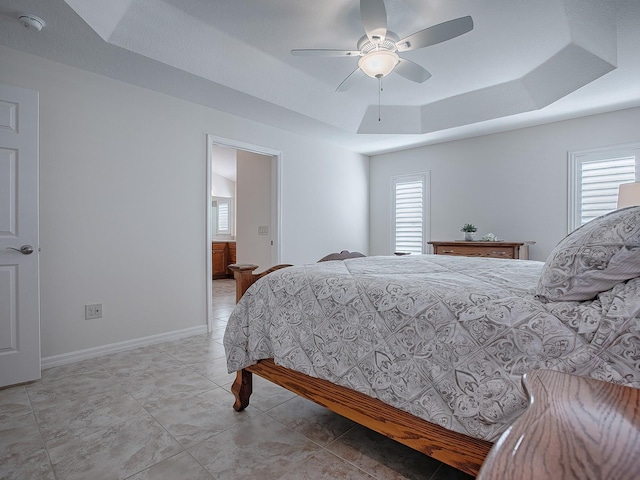 bedroom with a raised ceiling and ceiling fan