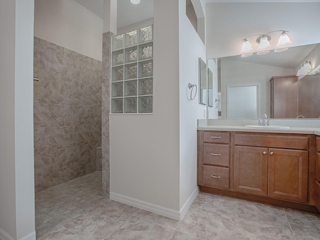 bathroom with vanity and a tile shower