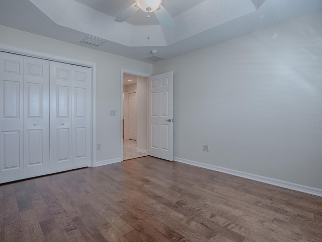 unfurnished bedroom featuring ceiling fan, a closet, and light wood-type flooring