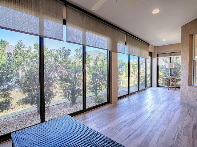 unfurnished sunroom with ceiling fan