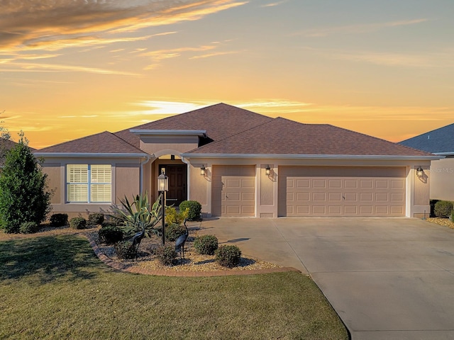 prairie-style home featuring a garage and a yard