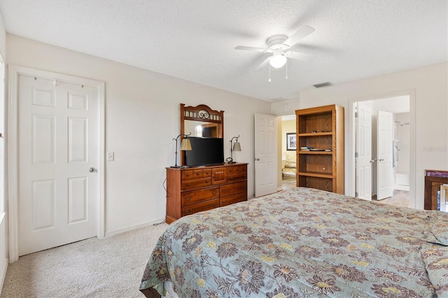 carpeted bedroom with ceiling fan, connected bathroom, and a textured ceiling