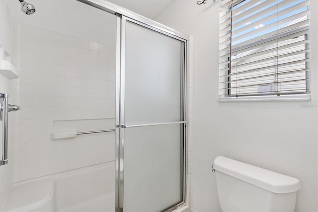 bathroom featuring toilet and an enclosed shower