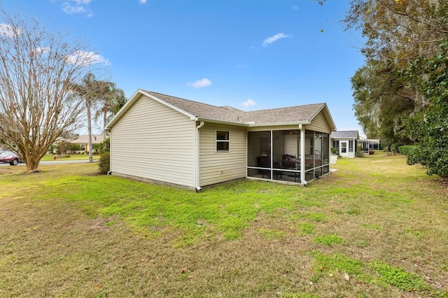 rear view of property with a yard and a sunroom