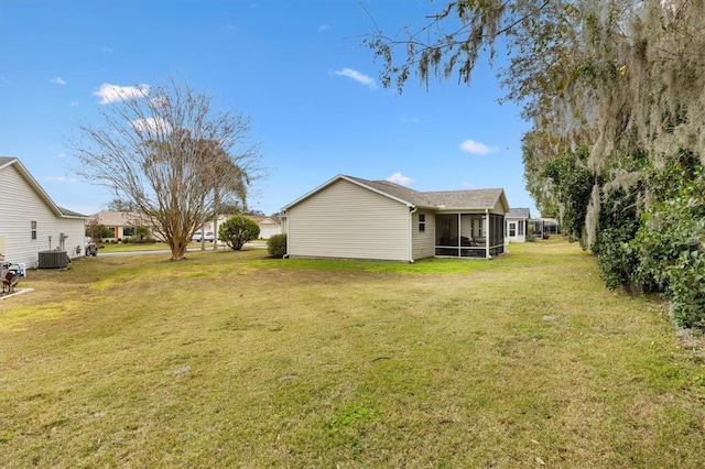 view of yard featuring a sunroom and central AC unit