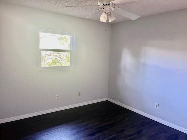 unfurnished room with a textured ceiling, ceiling fan, dark wood finished floors, and baseboards