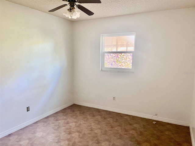 empty room featuring ceiling fan, baseboards, and a textured ceiling