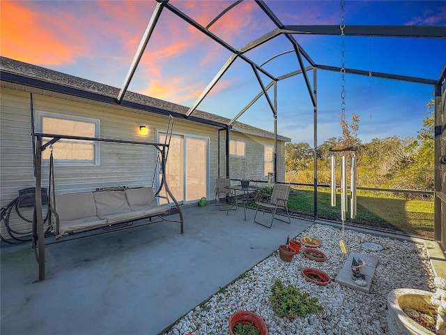 patio terrace at dusk featuring a lanai