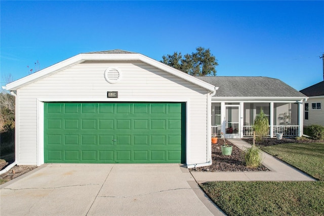 single story home with a front yard, a sunroom, and a garage