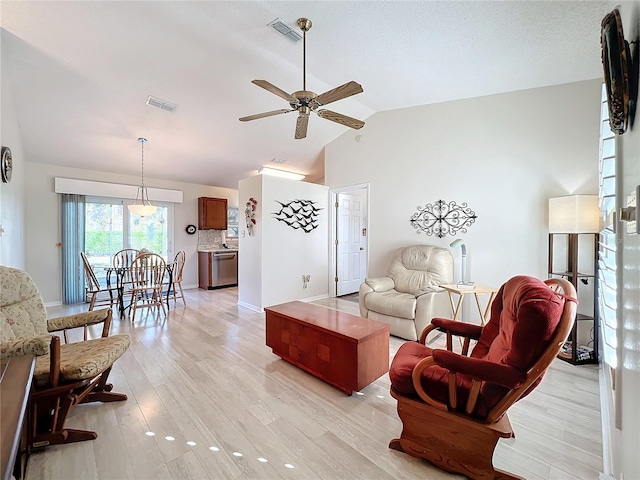 living room featuring ceiling fan, light hardwood / wood-style flooring, and lofted ceiling