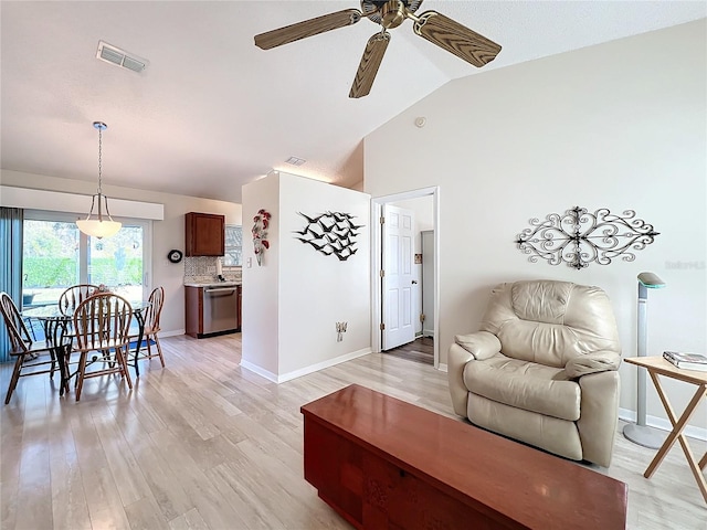 living room featuring ceiling fan, light hardwood / wood-style floors, and lofted ceiling