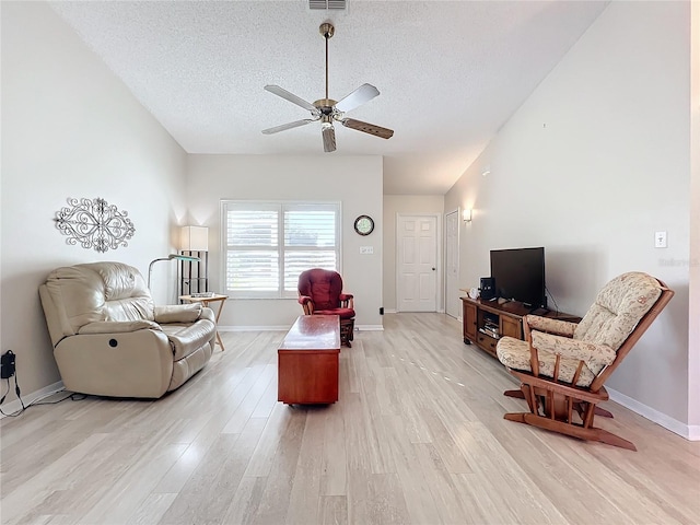 living room featuring a textured ceiling, ceiling fan, and light hardwood / wood-style floors