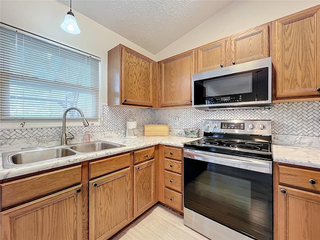 kitchen with stainless steel appliances, hanging light fixtures, decorative backsplash, sink, and lofted ceiling