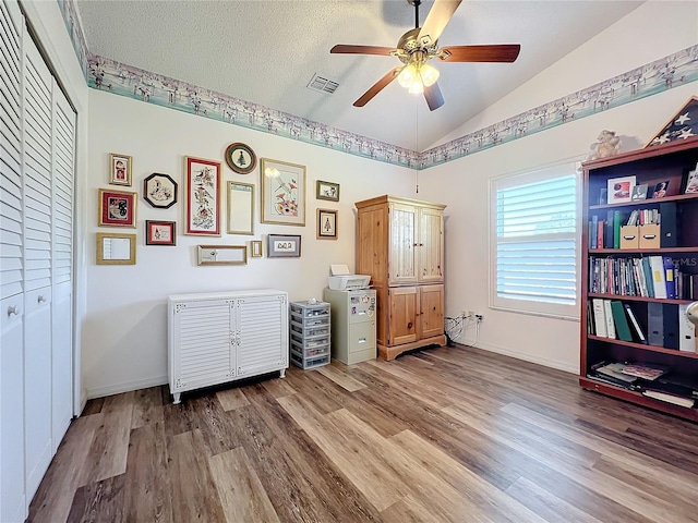 misc room featuring a textured ceiling, ceiling fan, vaulted ceiling, and wood-type flooring