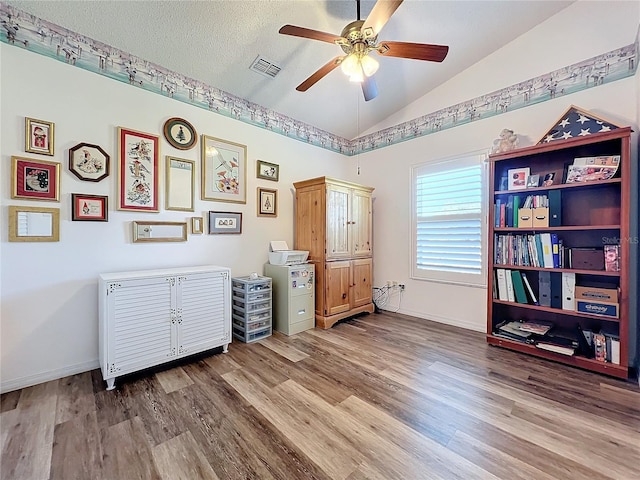 misc room with a textured ceiling, ceiling fan, vaulted ceiling, and wood-type flooring