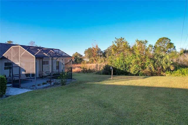 view of yard featuring a patio area and glass enclosure