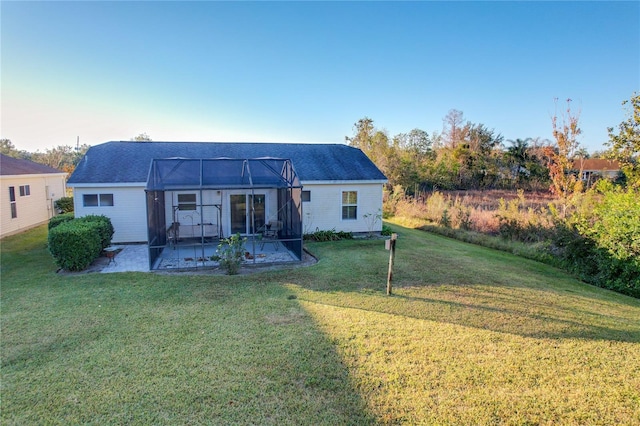 back of house with a patio, glass enclosure, and a yard