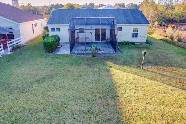 rear view of house with a patio and a lawn