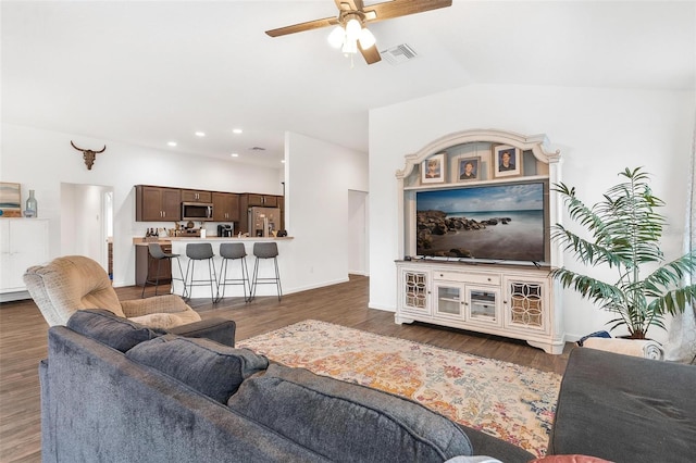 living room featuring lofted ceiling, ceiling fan, and dark wood-type flooring