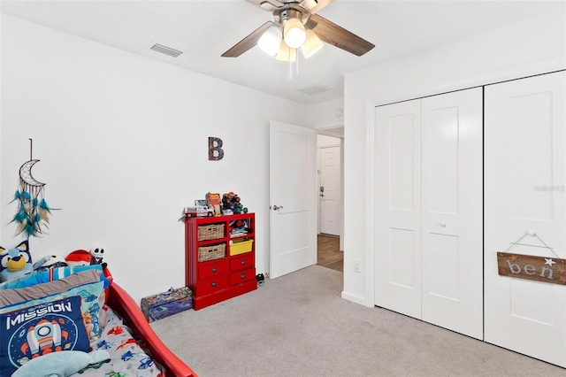 carpeted bedroom featuring ceiling fan and a closet