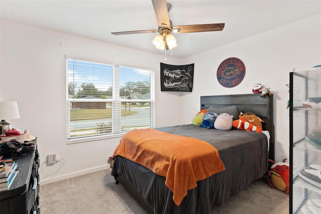 bedroom featuring ceiling fan, multiple windows, and light carpet